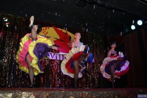 Three dancers performing the cancan